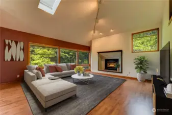 Spacious living room with beautiful hardwood floors, FP. skylights and natural lighting.