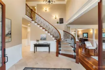 Grand staircase with vaulted ceilings and extensive trim detailing throughout the home.