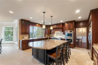 This kitchen has everything with built in refrigerator, double ovens, microwave, warming drawer, Vikiing cookrange, and dishwasher. Island with a sink and lots of room for seating. Cherry cabinets with a black glaze and black island. Lower cabinets have roll outs in them. Beautiful view out kitchen window.