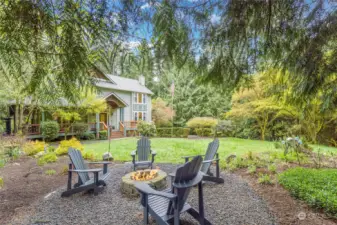 The property features a lush yard space in the front of the house with a cozy outdoor fire pit.