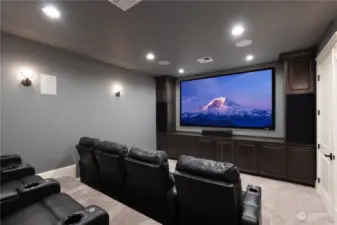Theatre with 120" projection screen, 9.1 surround sound, and theatre seating.