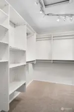 Primary suite walk in closet with custom built in shelving.