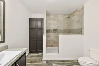 Oversized fully tiled walk-in shower, that has actually never been used! Large storage cabinet PLUS a huge closet as well
