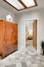 Back to the entry, a discrete second suite is accessed through the antique wood door.
