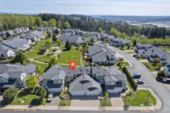 Aerial view of home. Designated guest parking is off to the right. Beautiful and open green space out the back door with putting green, trails and picnic area!