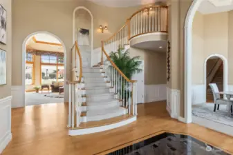 You have arrived! Opulent foyer with inlaid tile and open balustrade staircase.