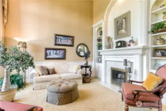 Soaring vaulted ceiling in the beautiful formal living room. Includes wainscoting & chair rail, built in cabinetry, bookshelves and fireplace.