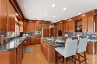 Sophisticated and practical kitchen adorned in stainless steel, granite counters & backsplash, gas cooktop & extensive timber flooring. This stunning custom kitchen also comes with a huge central island, vegetable sink, Sub Zero refrigerator & alfresco deck access.
