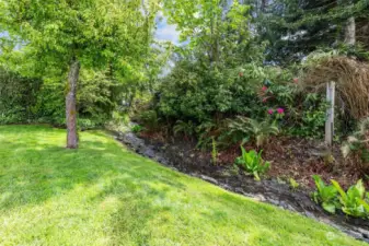 Don't miss the tranquil backyard with concrete patio and natural water feature!