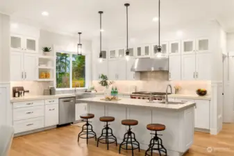 This kitchen defines "Chef's Kitchen". Quartz  countertops, Wolf 6-burner range, double  oven, oversized island with deep stainless  prep sink, stainless apron sink overlooking  the backyard, Dacor Column refrigerator,  Bosch stainless dishwasher, Sharp drawer  microwave, loads of counter space and  storage, the list is long!