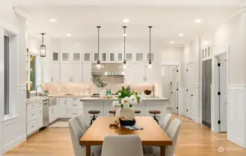 This area is cheerful and inviting on even the  gloomiest of days thanks to the abundant  natural light flowing in through the large  windows, the high ceilings, and both  recessed and pendant lighting. Under  cabinet lighting is also found in this custom  kitchen. The walk in pantry is next to the  refrigerator.