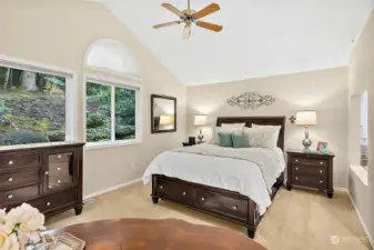 Primary bedroom is spacious with vaulted ceilings and a ceiling fan.  You'll love the peaceful views looking out at the woods.