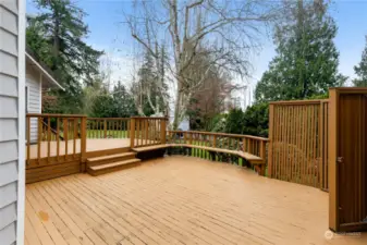 expansive tiered deck ready for summer gatherings and bbq's.  Has built-in seating!  Looking out into the fabulous landscaped backyard.