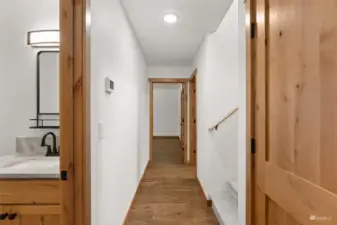 Down the hallway with a half bath to the left, stairs to the left and primary bedroom straight ahead.
