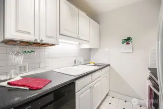 The kitchen is cleverly laid out and includes a subway tile backsplash, full sized refrigerator with ice maker and a dishwasher.