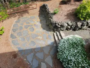 A nice stone patio has been created at the bottom of the path.