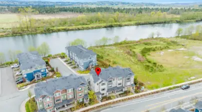 East/West oriented home has view of the Snohomish River, valley and mountains from living room, balcony and primary suite