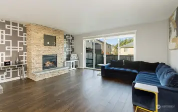 Family room with stone tiled gas fireplace for ambiance and those chilly winter nights. Custom dog crate in the corner with doggy door to outside. Oversized slider to backyard.