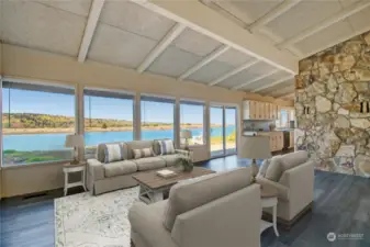 Living room with high vaulted ceilings and views of the Channel.  New luxury vinyl plank flooring. Virtually staged.