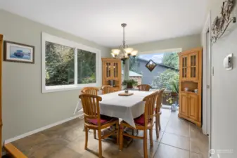 Sun-filled dining room with floor to ceiling atrium window, looking out to yard and garden and wildlife at play.  Great space for anytime of the day.
