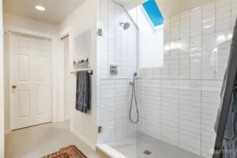 Enlarged shower with glass doors. Bathroom has two large walk-in closests.