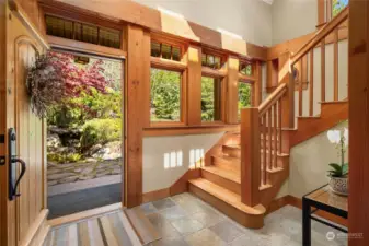 The entry hall leads upstairs via a wide, solid wood staircase.