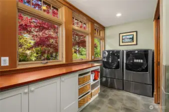 Spacious laundry, with plenty of storage, views onto the gardens and long counter for folding clothes.