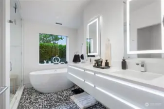 Primary suite bathroom with custom marble terrazzo tile floors, dual sinks, oversized shower and soaking tub.