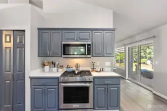 The natural gas stove is surrounded by counter top and cabinet space