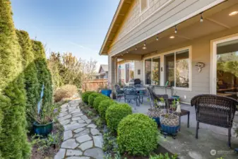 Covered patio and a charming flagstone path lined with boxwoods and forget-me-nots