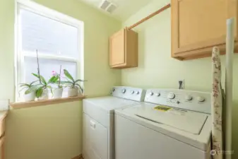 The main floor laundry room has extra cabinets, a window, and a laundry sink.  Both the washer and dryer are included.