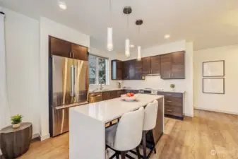 The kitchen boasts ample storage, quartz countertops, and high-end stainless-steel appliances.