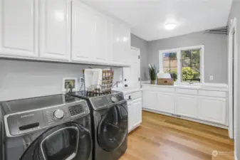 Huge mud room/laundry room with another entrance from outside, features a side-by-side washer & dryer, custom cabinets with abundant storage, utility sink & a drying rack. There's even another bathroom in the laundry room, making for a total of six!