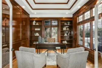 The study  features rich, wood panels with built-in shelves  Exquisite custom millwork & coved ceiling treatment.