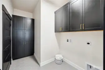 Main level laundry room with pantry and additional storage.