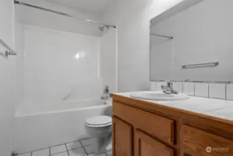 Full guest bathroom with shower/tub combo and tile flooring.