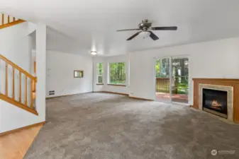 Flowing downstairs living space with ceiling fan.