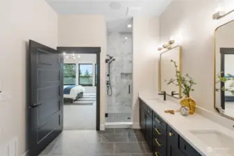 Primary bathroom with elegant walk-in tile shower, lovely dual sink quartz vanity and tile flooring.