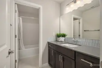 Upstairs Hall Bathroom with a large sink vanity, stone flooring, and a door separating the toilet and tub/shower