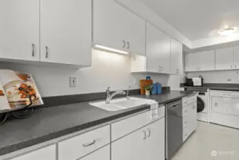 The kitchen is equipped with new matching Frigidaire stainless steel appliances and elegant Corian counters