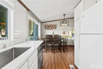 Tasteful updates in kitchen with quartz countertops and bright white subway tile.