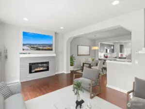 Home is virtually staged - Light filled living room with electric fireplace and hardwood flooring.
