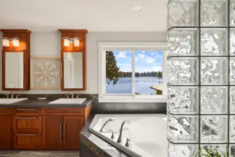 Large soaking tub with views of the lake and mountain plus a oversized walk in shower and heated floors
