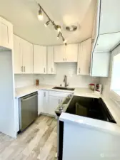 Bright, Fully-Remodeled, Modern Kitchen w/New: Paint, Cabinets, Quartz Counters, Tile Backsplash, Flooring, Lighting, Dishwasher, Large Stainless Sink/Faucet, Electric Oven/Stove w/window to deck and backyard - Day