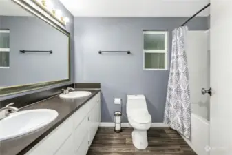 Large full bath upstairs with two sinks and upgraded flooring.