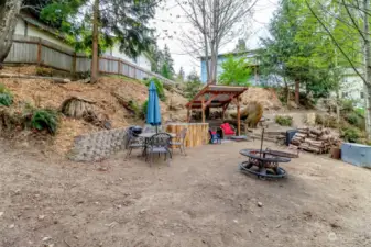 The backyard features an outdoor kitchen, zipline, rope swing, and firepit.