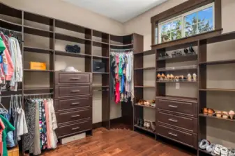 Primary walk in closet with custom built ins.
