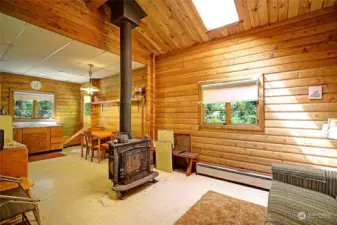 Inside this harming cabin with well configured space with a wood stove, kitchen and dining areas, and open floor plan to enjoy.