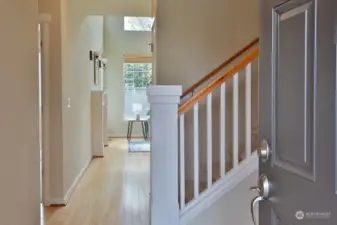 Solid beech wood floors greet you upon entry. The Primary Suite is to the right (before the stairs), across from the stairs and to the left is a hallway that leads to the 2nd BR, Full Bath, Laundry Room & Garage. Straight ahead is the open living/dining/kitchen area.