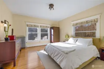 The primary suite is timeless with large windows and original trim and hardwood flooring.